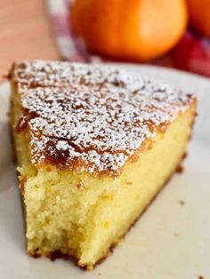 a piece of cake sitting on top of a white plate next to some oranges