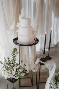 Three tier white iced vegan wedding cake with black taper candles and wedding drapes Wedding Cake Traditional, Wedding Cake Black And White, Wedding Cake Setup, Wedding Cake Black, Cake Black And White, Drapes Wedding, Wedding Cake Display Table, Wedding Cake Table Decorations