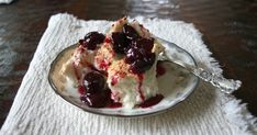 a small bowl filled with ice cream and cherries on top of a white place mat