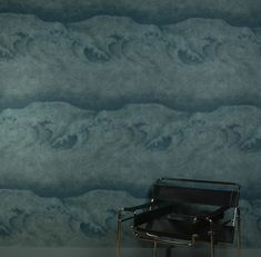 a chair sitting in front of a wall with waves painted on it