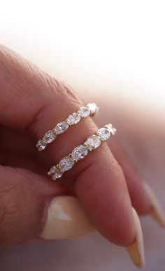 a woman's hand with two rings on top of her finger and one ring in the middle