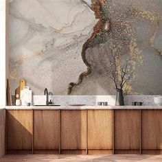 a kitchen with marble counter tops and wooden cabinetry in front of a wall mural