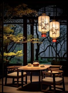 a table with chairs and two lanterns hanging from it's ceiling in front of trees