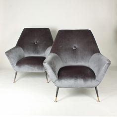 two gray chairs sitting next to each other