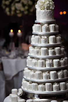 a wedding cake with white frosting and flowers on the top is surrounded by other desserts