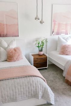 two white beds with pink pillows in a bedroom next to a nightstand and painting on the wall