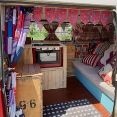 a small living area with a couch, television and other items in the inside of it