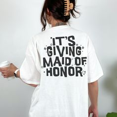 a woman with her back to the camera wearing a white shirt that says in my maid of honor era