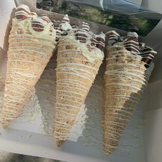 three ice cream cones sitting on top of a white tray