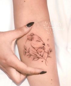 a woman's arm with a tattoo on it and a bear sitting in the middle