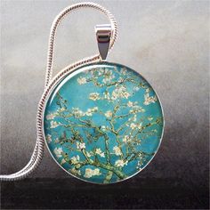 a glass pendant with an almond blossoming tree in bloom on a blue sky background