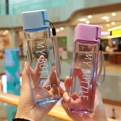 two people holding up water bottles with the words i love my mom on them