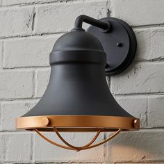 a black and gold light fixture on a brick wall