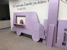 there is a cardboard truck with a shelf in the middle of it that has a stuffed animal inside