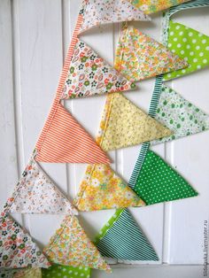 a bunch of small triangles hanging on a wall with polka dots and floral designs