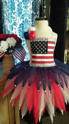 a mannequin with an american flag tutu and red white and blue feathers