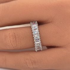 a woman's hand with a diamond ring on her left hand, showing the side view