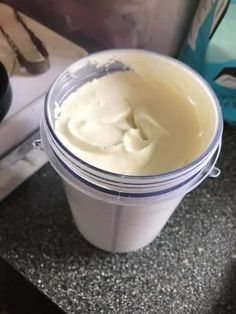 a plastic container filled with cream sitting on top of a counter