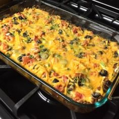 a casserole dish sitting on top of an oven with lots of toppings