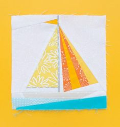 an origami sailboat made out of paper on a yellow background with white and blue trim