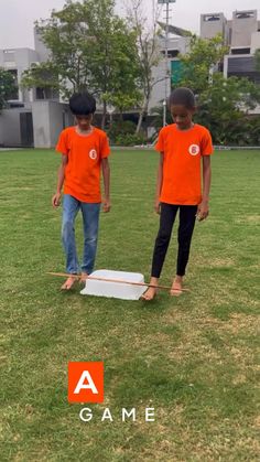 two young boys standing on top of a white object in the middle of a field