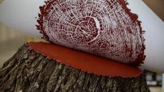 a piece of wood that has been cut into pieces with red paint on it and is sitting on top of a tree stump