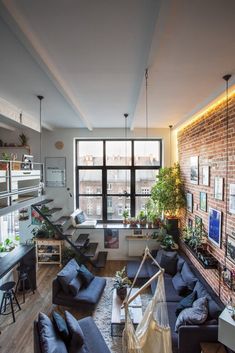 a living room filled with furniture and lots of windows next to a wall mounted tv