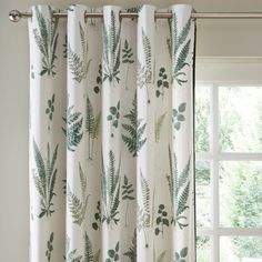 a curtain with green leaves on it in front of a window