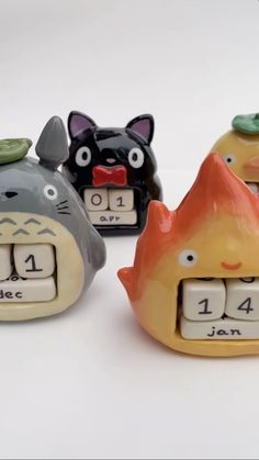 three ceramic clocks with animals on them sitting next to each other in front of a white background