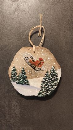 a wooden ornament with a santa sleigh flying over the snow covered trees