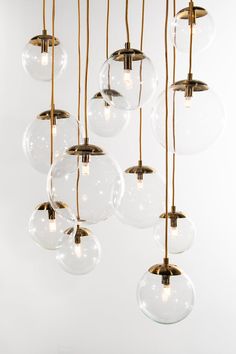 a bunch of clear glass balls hanging from a chandelier with gold metal fittings