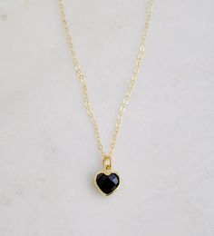 "Crafted onto a 14k gold filled chain and set in 24k gold electroplate, this black onyx heart is as precious as the affection it symbolizes. Make it that perfect gift for someone special, including yourself! Exuding protective and calming energies, Black Onyx is associated with the root chakra. It's believed to be an \"anti-panic\" stone which soothes stress and helps clear mental confusion and hyperactivity. GEMSTONE: Black Onyx STONE SIZE: average 10mm (.39\")  STONE SHAPE: Faceted Heart (Hear Black Heart-shaped Jewelry For Anniversary, Black Necklaces For Anniversary On Valentine's Day, Black Necklace For Anniversary On Valentine's Day, Valentine's Day Black Necklace For Anniversary, Black Gold Plated Charm Necklace With Adjustable Chain, Black Adjustable Chain Heart Pendant Jewelry, Gold Plated Black Jewelry For Gift, Black Gold-plated Adjustable Chain Jewelry, Black Gold Plated Jewelry As Gift