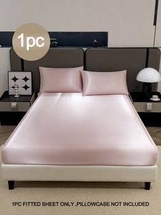 a bed with pink sheets and pillows on it