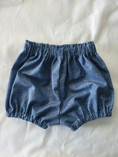 a pair of blue shorts laying on top of a bed