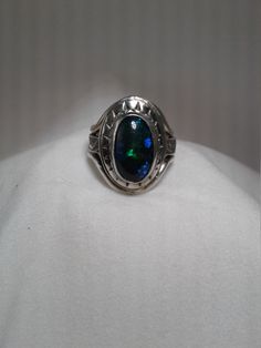 Beautiful blackl opal (3/8 x 5/8) 9 x 16mm with patterned sterling silver band and decorative bezel.  Made with Sterling, Fine silver and Argentium silver. Lots of green and blue flash in opal.  Terrific  gift for the October birthday or Christmas gift. This is a one of a kind ring so only available in size 7 1/2. I have other black opals but they are not as large as this one.  If you are interested in having a ring made with a smaller black opal, contact me. Sterling Silver Oval Opal Cabochon Ring, Hallmarked Oval Opal Ring, Hallmarked Oval Ethiopian Opal Rings, Oval Cabochon Opal Ring In Sterling Silver, Oval Opal Rings With Polished Finish, Silver Oval Opal Ring, Silver Opal Ring With Oval Cabochon, Polished Opal Ring In Oval Cabochon Shape, Opal Oval Cabochon Ring With Polished Finish