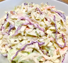 a white bowl filled with coleslaw on top of a table