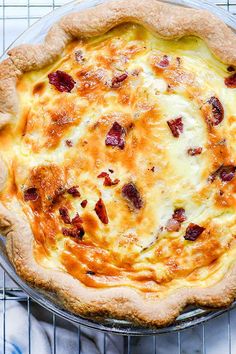 a cheese and bacon pie sitting on top of a cooling rack