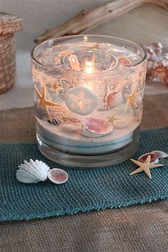 a candle that is sitting on top of a table next to some seashells