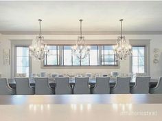 a large dining room table with chairs and chandelier hanging from it's ceiling