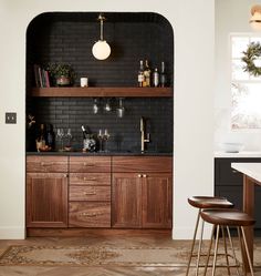 a kitchen with black brick walls and wooden cabinets, gold accents on the countertops