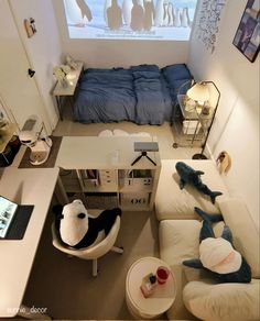 an aerial view of a living room with white furniture and blue sheets on the bed