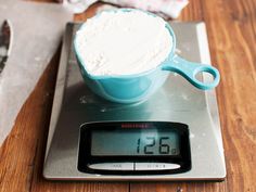 a blue measuring cup sitting on top of a scale