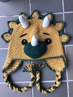 a crocheted animal hat on the floor with a rope around it's neck