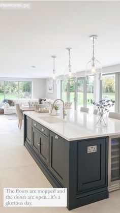 a large kitchen with an island in the middle and lots of windows on both sides