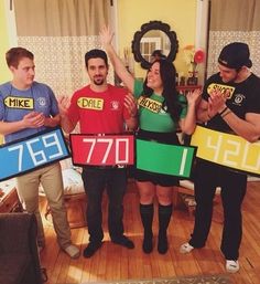 four people holding up signs in the shape of numbers