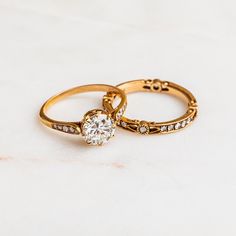 two gold wedding rings with diamonds on them