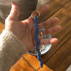 a person holding onto a blue rope on top of a wooden table next to a plate