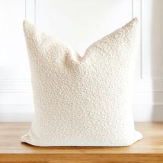 a white pillow sitting on top of a wooden table