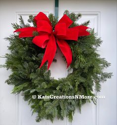 a christmas wreath with red bows hanging on a door