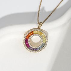 Radiance by Absolute™ 9.76ctw Round & Baguette Rainbow Circle Pendant There's no end to the rainbow of styling possibilities you'll discover in this circle pendant with chain. Lots of sparkling, simulated diamond color make the spirited design such a vibrant and versatile look. Wear the pendant as a statement single. Layer it with other pendants, chains and necklaces. Either way, it's a fab choice for special days or any day.        Pendant approx. 15/64"L x 15/64"W     Chain approx. 18"L with 2" extender     Stamped .925 sterling silver; yellow gold plating; polished finish      Link chain: lobster-claw clasp    Stone Information       All sizes and weights, including diamond equivalent weights (DE), are approximate      Total Carat Weight: 9.76ctw; 5.76ctw (DE)     Mixed Color Absolute S Modern Round Rainbow Jewelry, Modern Rainbow Round Jewelry, Rainbow Cubic Zirconia Round Jewelry, Fine Jewelry With Multicolor Baguette Diamonds, Rainbow Round Diamond Jewelry, Rainbow Colored Round Diamond Jewelry, Rainbow Circle, Pendant With Chain, Signature Jewelry